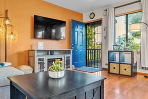 A modern living room with a fireplace, a blue door, and a view of the outdoors. - NEW Rustic Retreat, 15min to Beach, Top Location. Renovated 2bed/1bath Apartment (Los Angeles)
