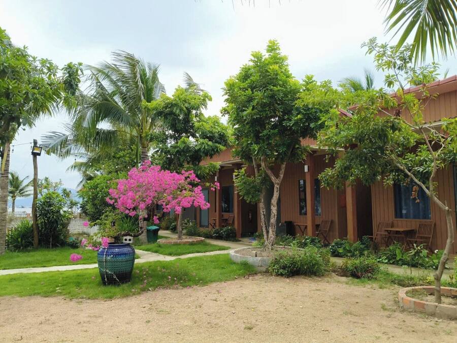 A bungalow with a garden, a pathway, and a view of the sea.
