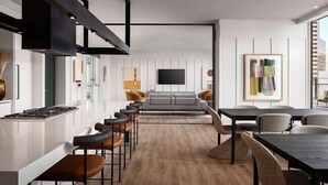 A modern kitchen with a central island, bar stools, and a dining area with a table and chairs.