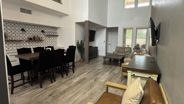 A spacious living area with a dining table, chairs, a sofa, and a ceiling fan. - Modern Luxury Townhouse –  3-Suite Retreat (Mesa)