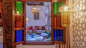 A room with a large mirror reflecting a dining area, a decorative wall with geometric patterns, and a hanging lantern. - Elegant Riad Musée: Authentic Marrakech Charm in the Medina (marrakech)