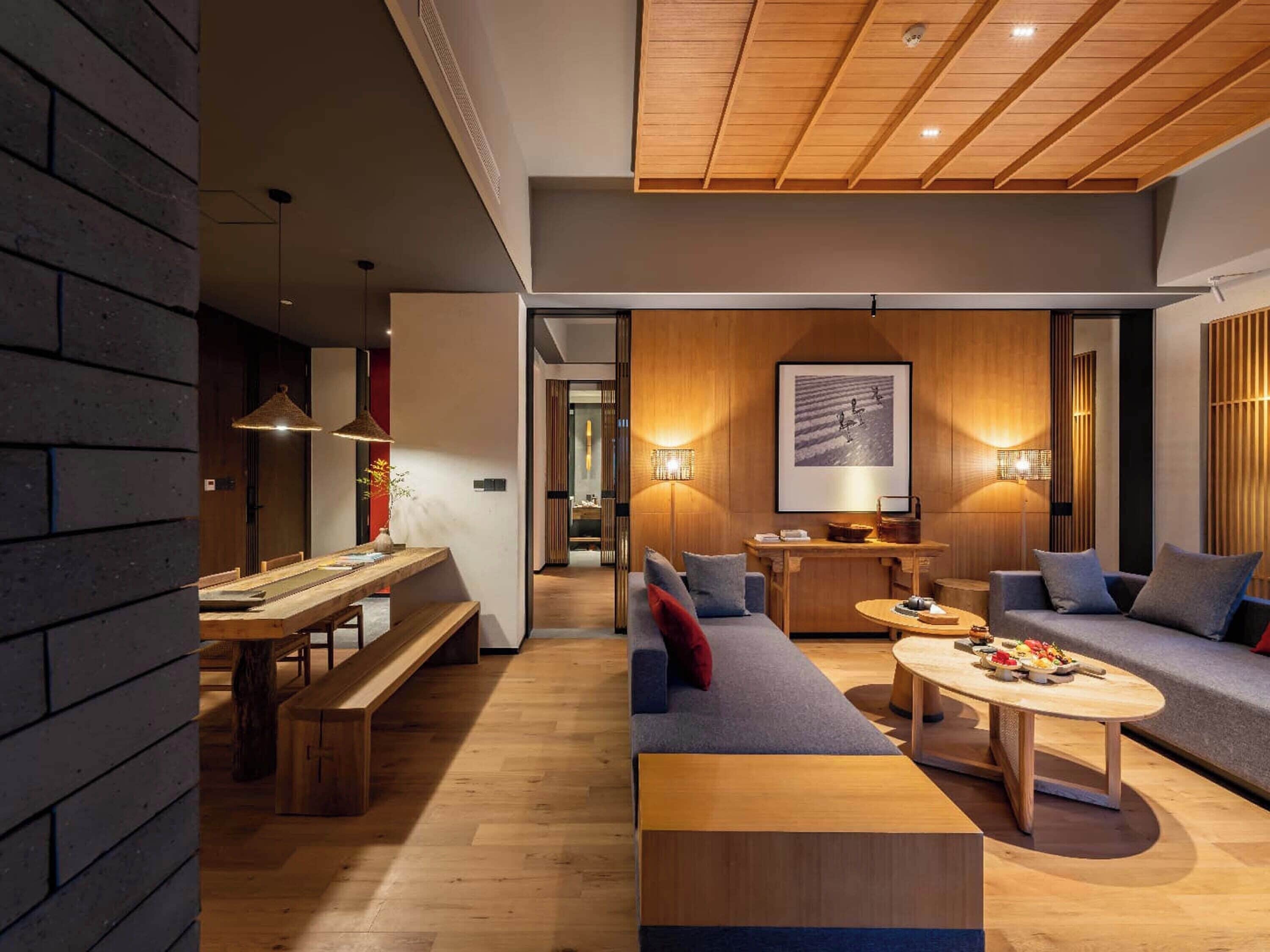 Un interior moderno con una mesa de comedor de madera, un sofá y una mesa baja.