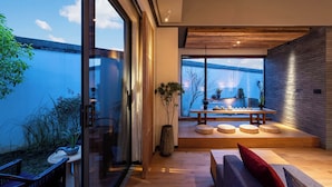 A modern interior with a dining area, large windows, and a view of the outdoors. - Tan She Tang Quan Resort Hotel-Huangshan (Huangshan)