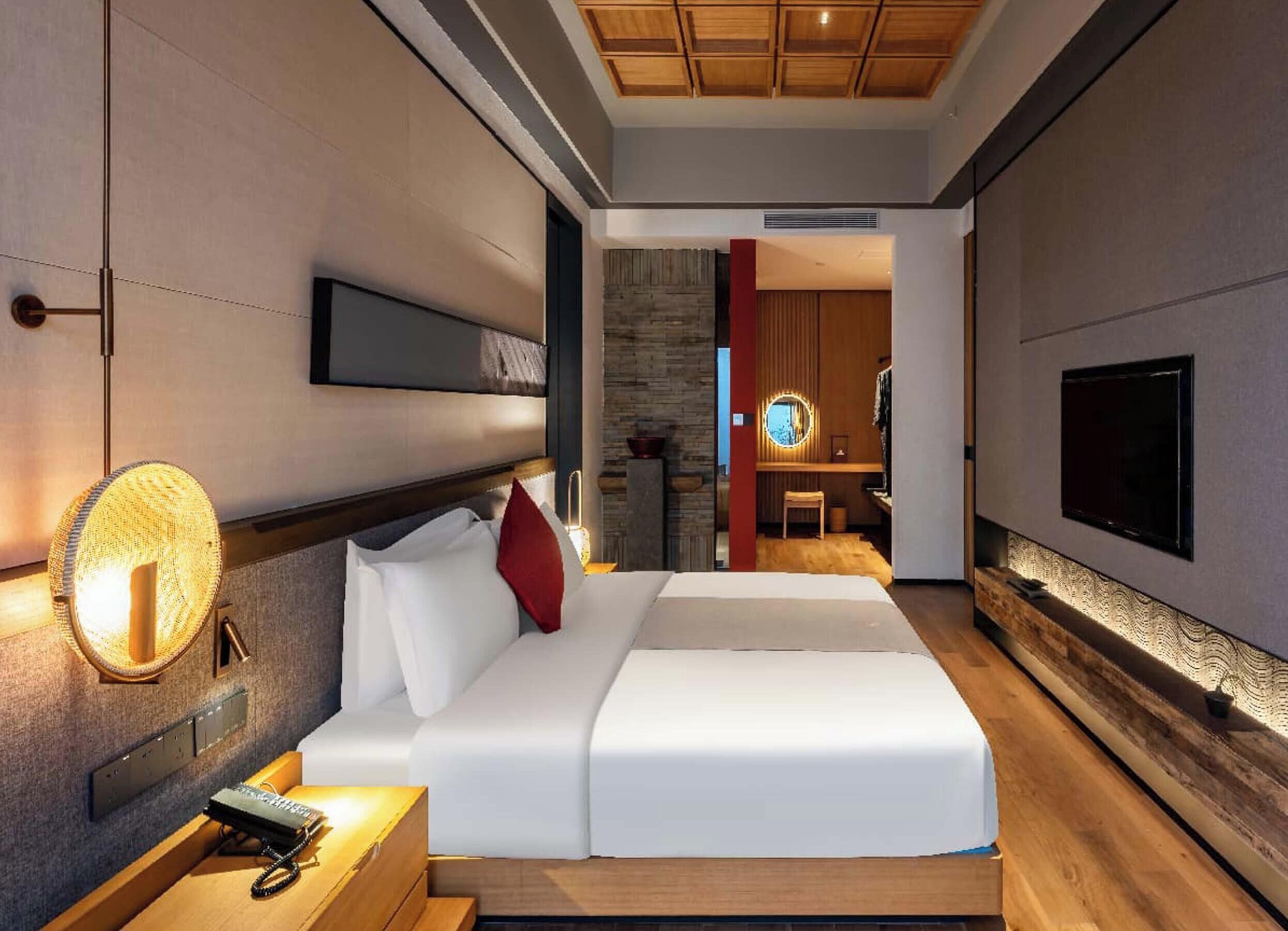 Habitació d'hotel moderna amb un llit gran, taules de nit, una televisió penjada a la paret i un sostre de fusta.