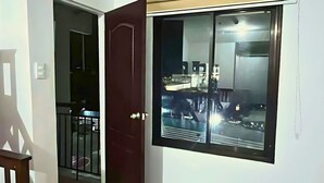 A room with a sliding door leading to a balcony, a large window with a view of the outside, and a small round table. - Spacious family-friendly apartment with Balcony! (Muntinlupa)