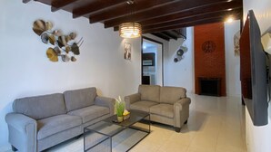 A living room with two sofas, a coffee table, and a fireplace. - Homestay Syariah Merapi View Simply Homy (Ngaglik)