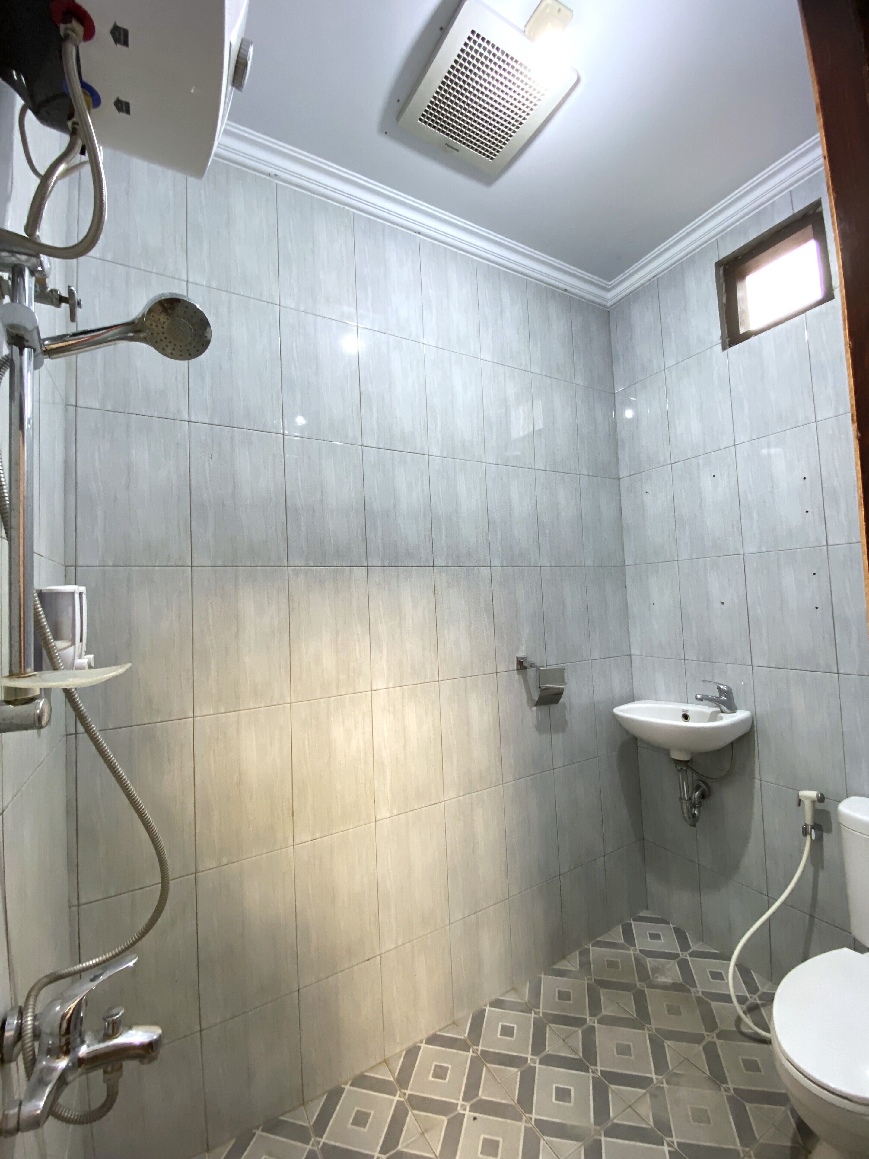 Un baño con ducha, lavamanos e inodoro.