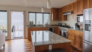 Une cuisine moderne avec des meubles en bois, des appareils en acier inoxydable et un grand îlot central.