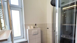 A modern bathroom with a sink, toilet, and glass shower enclosure.