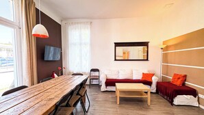 A modern living room with a wooden dining table, a sofa, and a coffee table.