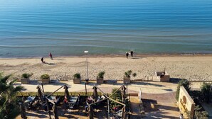 Vista para a praia com área de varanda, mobiliário externo e vista do mar.
