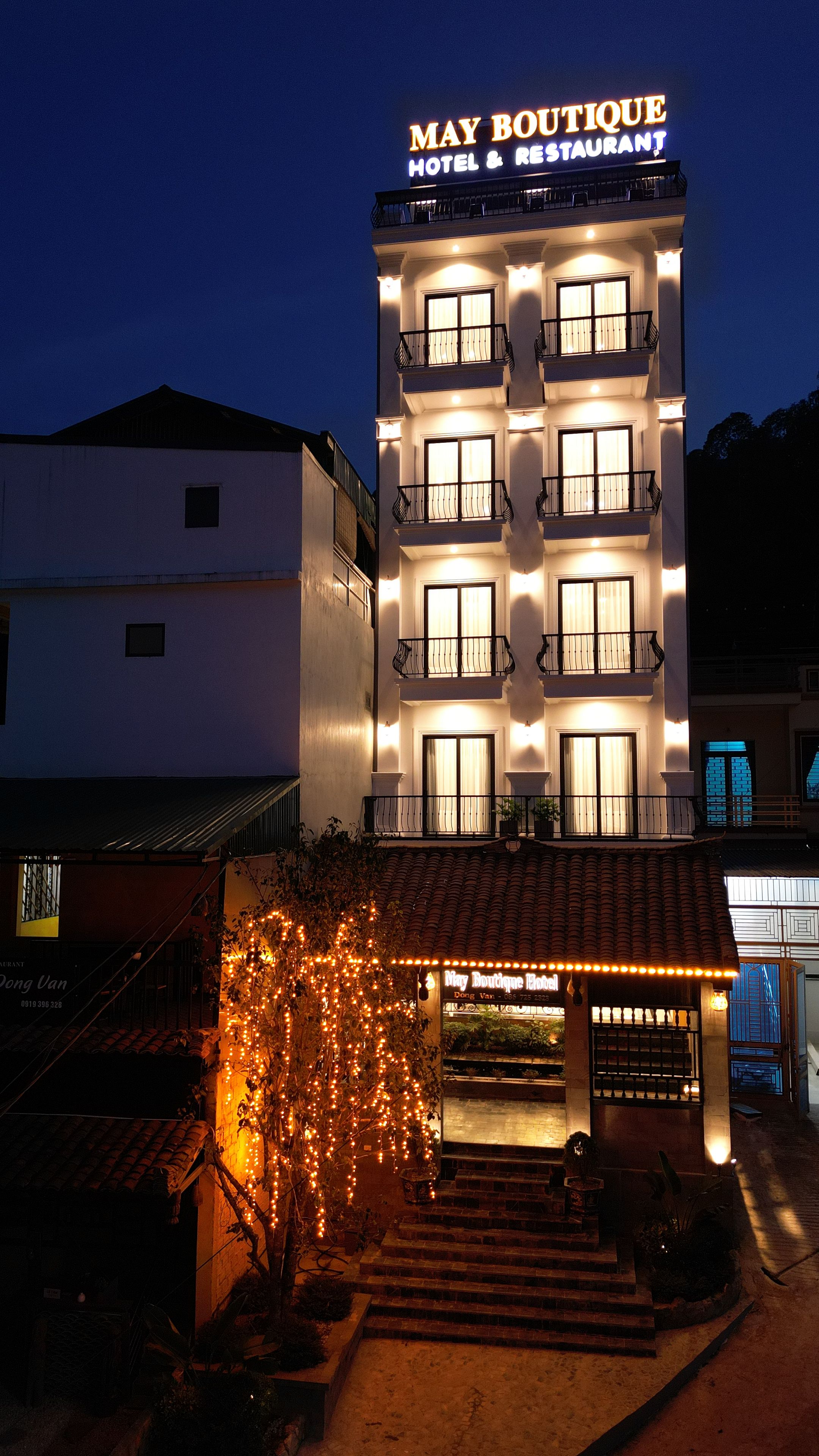 Un immeuble à plusieurs étages sur lequel on peut lire l’inscription : « May Boutique Hotel & Restaurant ».