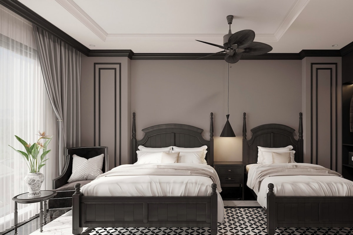Un lit double avec une tête de lit, une table de chevet, une commode, un ventilateur de plafond, une armoire et une plante en pot.