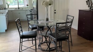 A modern kitchen with white cabinets, a glass dining table, and black chairs. - House with A Vibe in West Sacramento A Swimming Pool and five bedrooms. (West Sacramento)