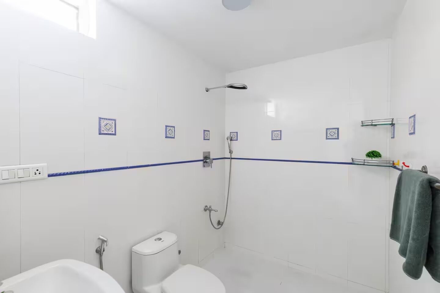 Een moderne badkamer met douche, toilet en wastafel.