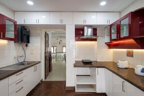 Une cuisine moderne avec des armoires blanches, une hotte en acier inoxydable et un plan de travail en bois.