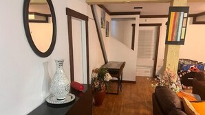 Un salon chaleureux avec une table basse en bois, un canapé et un coin repas comprenant une table et des chaises.