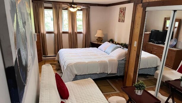 Une chambre avec deux lits, un canapé, une télévision et un miroir.
