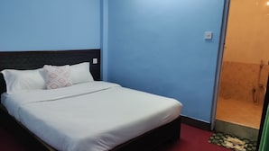 Un dormitorio con cama, zona de ducha y puerta.