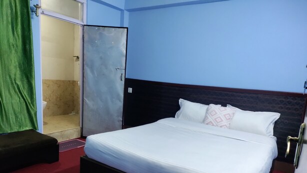 Una habitación de hotel con cama, armario y baño.