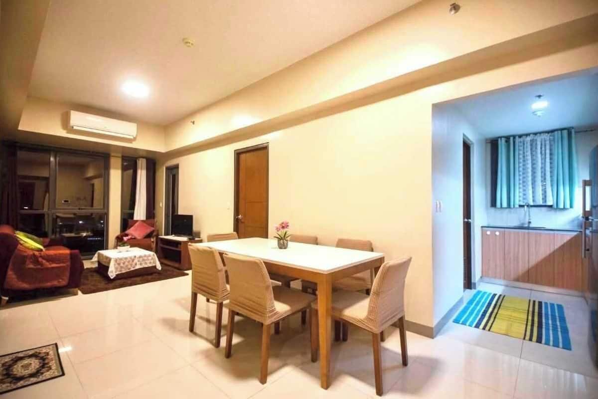 Un comedor con una mesa, sillas, un sofá y un televisor.