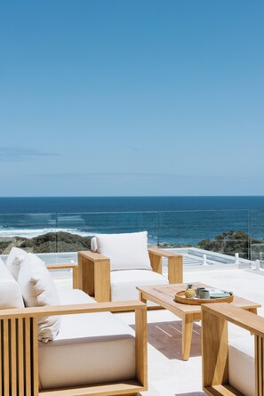 A terrace with wooden furniture and a view of the ocean. - "Yallingup Palms"  just a short walk to Yallingup Beach (Yallingup)