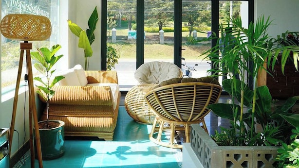 A sunlit room with a large window, wicker furniture, and a potted plant. - The Scent Boutique Dalat Hotel (Lam Vien - Da Lat)