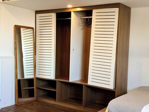 Ein Schlafzimmer mit einem Holzschrank, einem Spiegel und einem Bett.