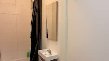 Eenvoudig appartement | Badkamer | Een douche, gratis toiletartikelen, een haardroger, handdoeken