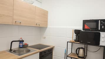 Eenvoudig appartement | Privékeuken | Een microgolfoven, een kookplaat, kookgerei, borden en bestek
