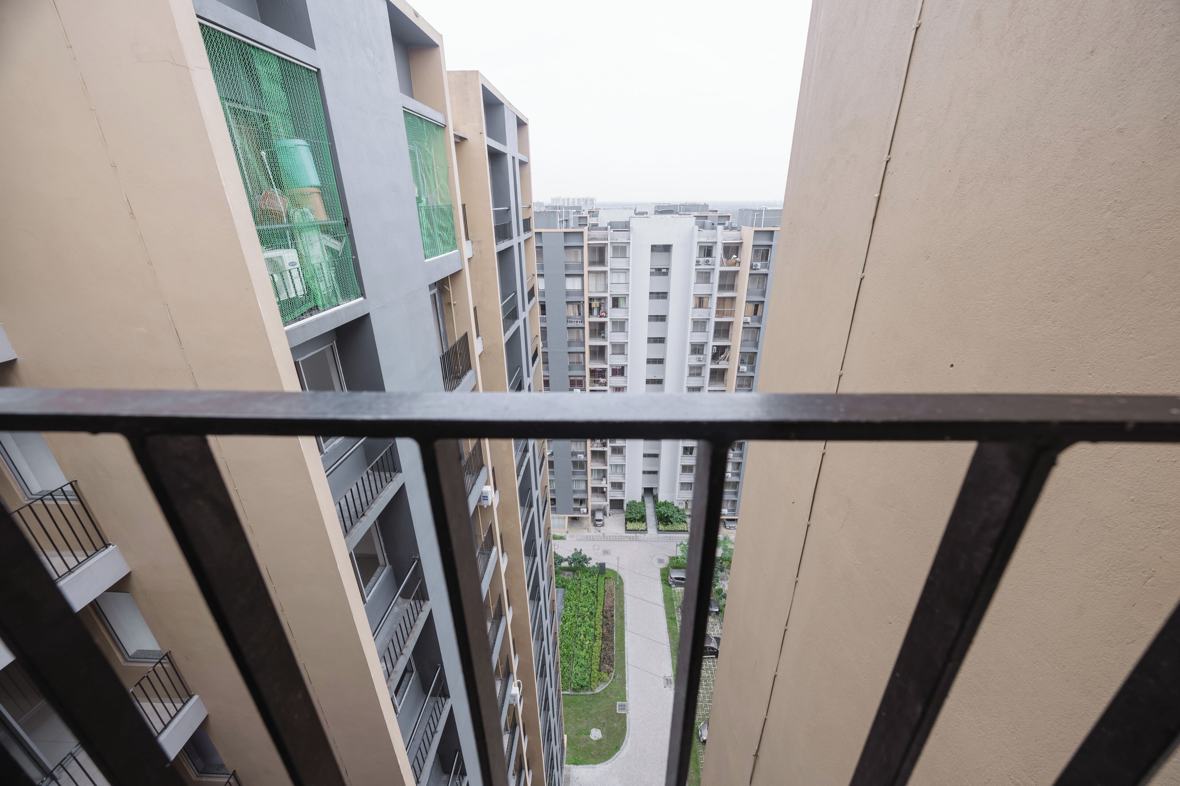 Een hoog appartementencomplex met meerdere balkons en een centrale binnenplaats.