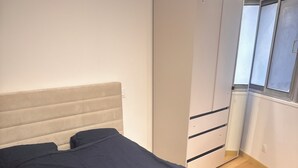 Ein Schlafzimmer mit einem Bett, einem Kleiderschrank und einem Fenster.