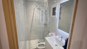 Ein modernes Badezimmer mit Dusche, Toilette und Waschbecken.