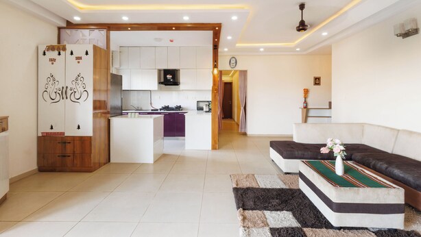 A modern living room with a sofa, a coffee table, and a kitchen area in the background. - Willow Height by Red Olive30min to Airport Veg (Bengaluru)