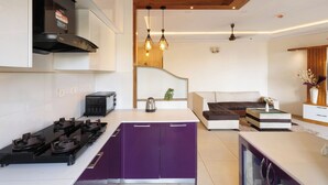 A modern kitchen with a central island, built-in appliances, and pendant lighting. - Willow Height by Red Olive30min to Airport Veg (Bengaluru)
