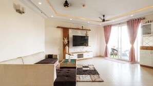 A modern living room with a sofa, TV, and a dining area with a table and chairs. - Willow Height by Red Olive30min to Airport Veg (Bengaluru)