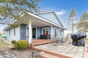 Eingeschossiges Haus mit überdachter Terrasse und Grill.