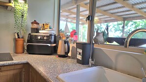 Eine Küche mit Kaffeemaschine, Wasserkocher und Kaffeemühle auf der Arbeitsfläche.