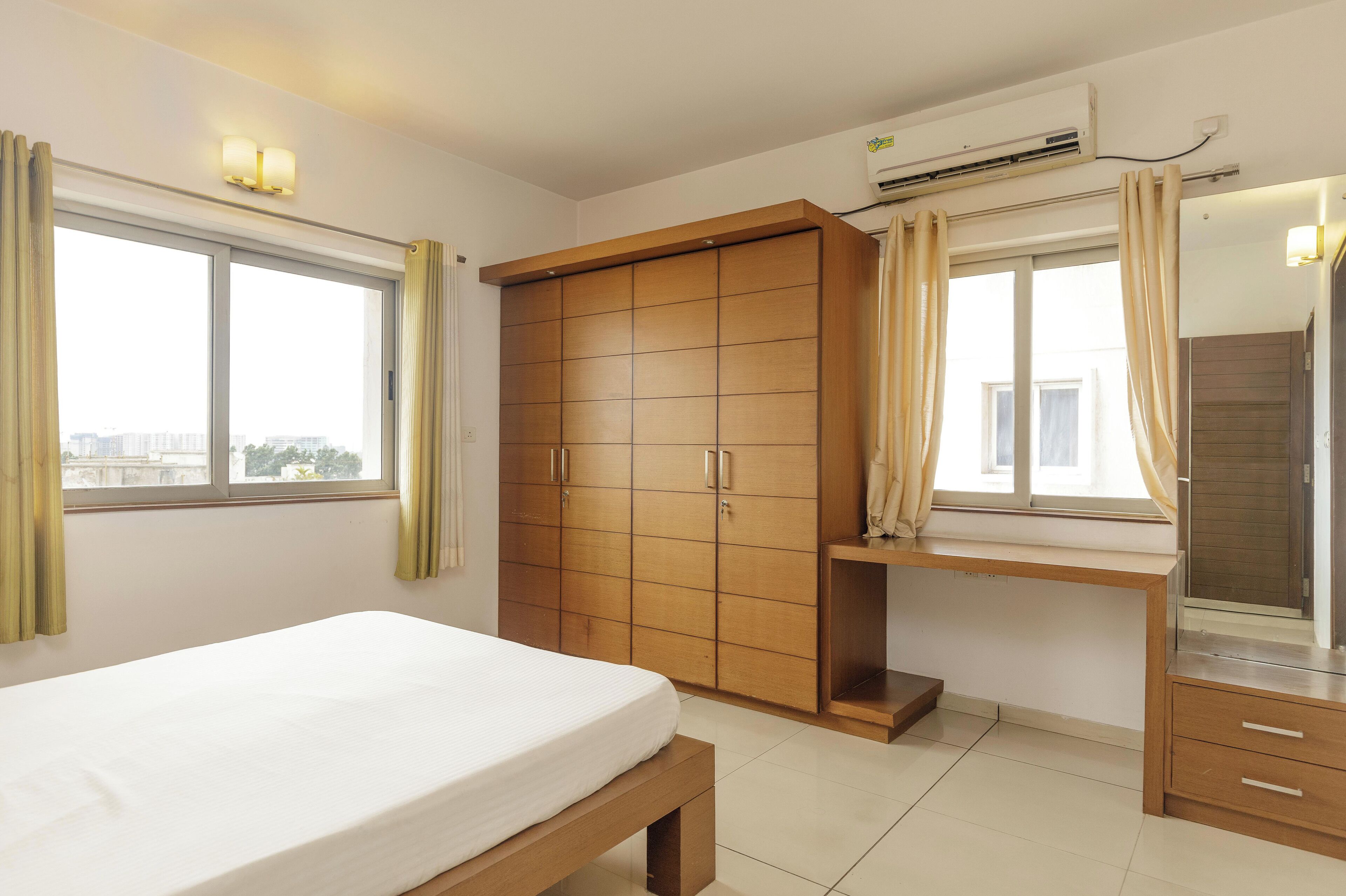 A bedroom with a bed, wardrobe, and a window with curtains.
