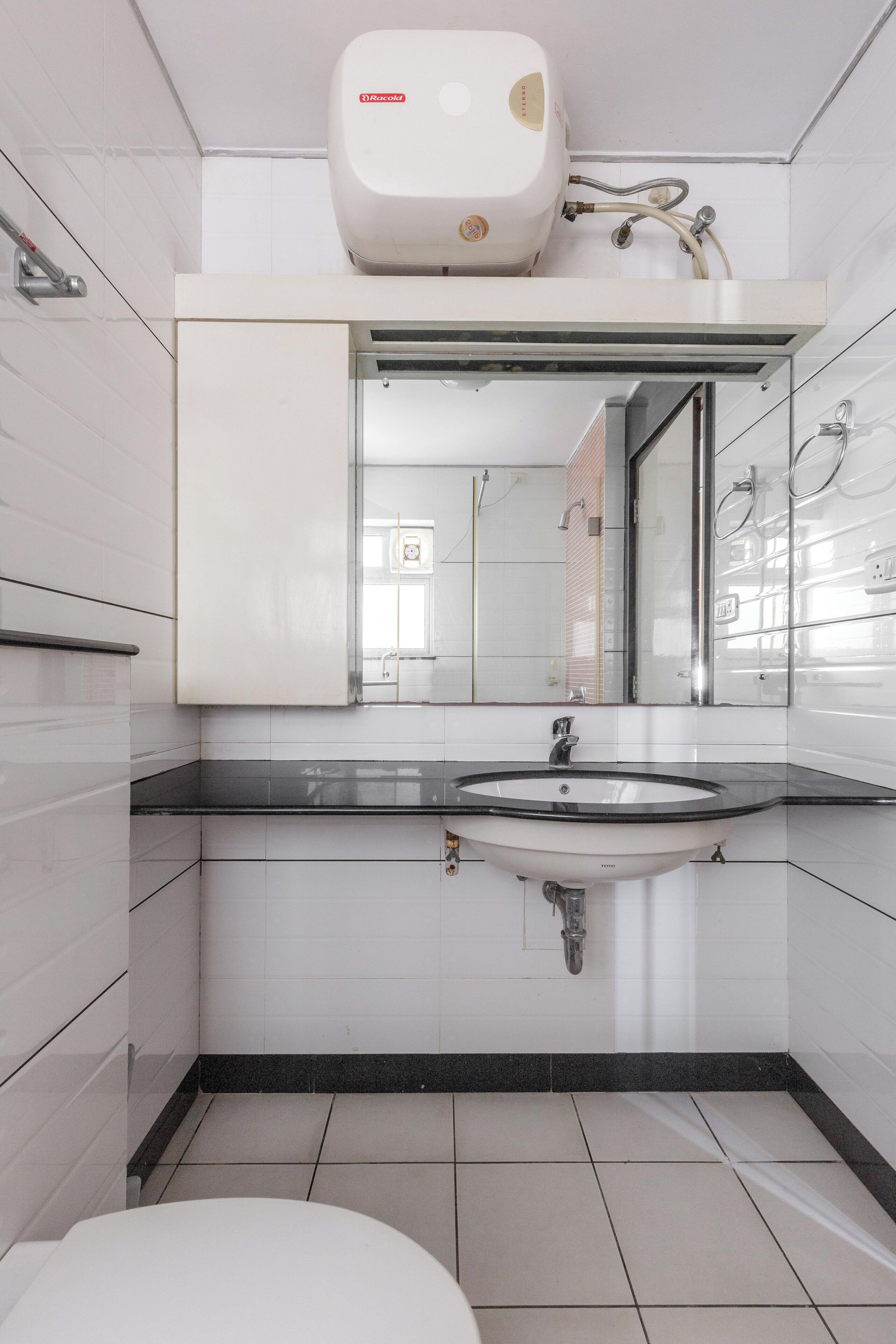 Een moderne badkamer met een wit wastafelmeubel, een spiegel en een wandgedroogde hand.'