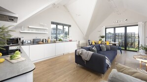 A modern loft apartment with a kitchen, dining area, and living room. - Cloud 10 St Ives - Sea Views - Free parking & WiFi - Pets Welcome (St Ives)