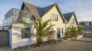 A modern two-story house with a sloped roof, large windows, and a balcony. - Cloud 10 St Ives - Sea Views - Free parking & WiFi - Pets Welcome (St Ives)