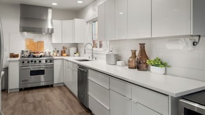 A modern kitchen with white cabinetry, stainless steel appliances, and a wooden countertop. - NFL Spacious Green Lake Home, Dog OK, BBQ/Karaoke (Seattle)