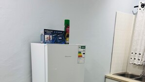 A compact kitchen with a white refrigerator, a sink, and a small countertop.