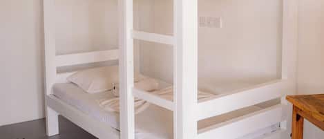 A bunk bed with a wooden table beside it.
