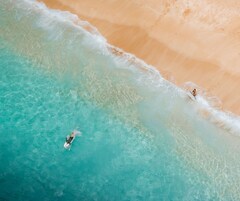 Een strand met helder turquoise water en een zandstrand.
