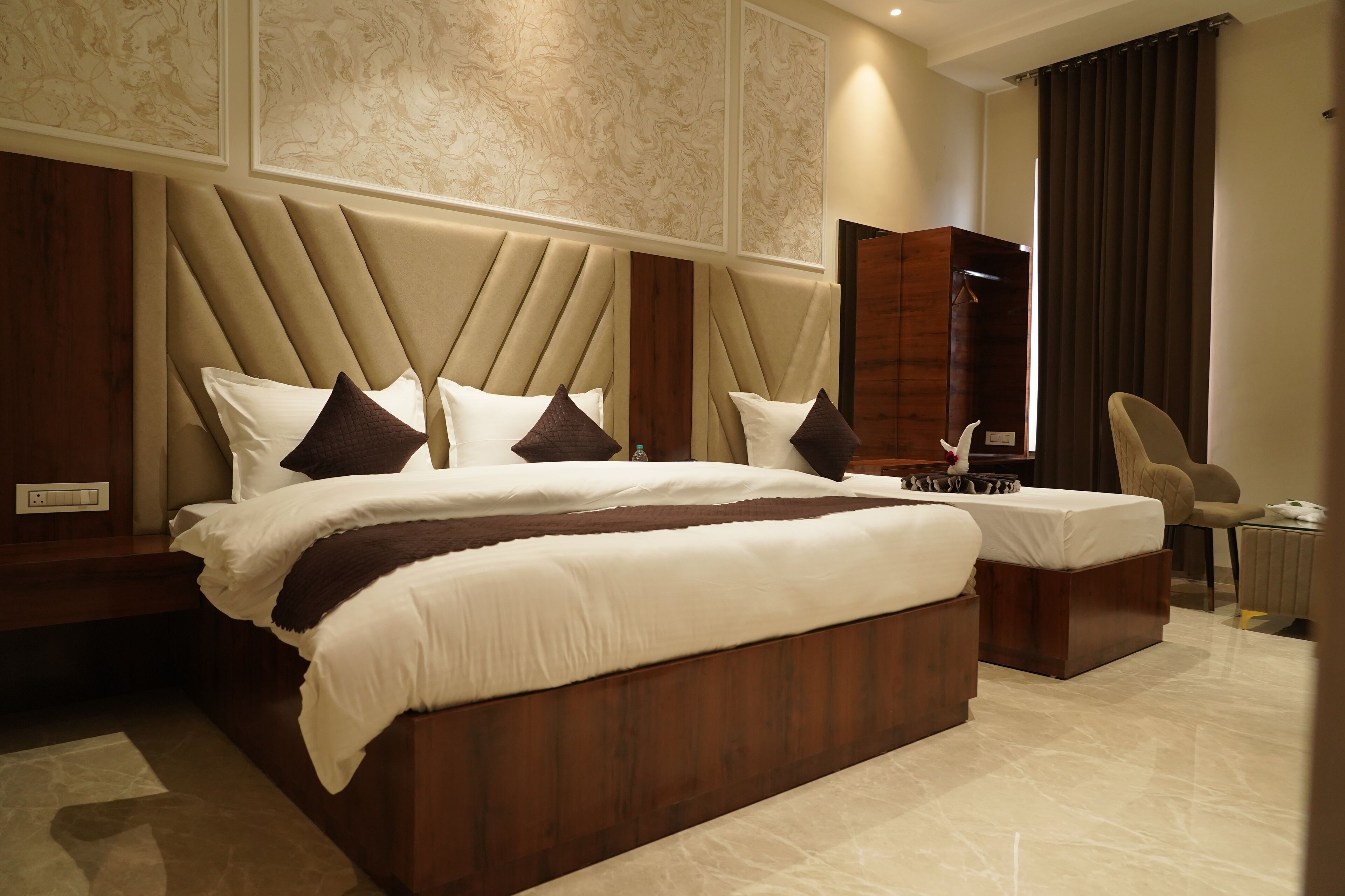 Una cama grande con cabecera de madera, una mesita de noche y una silla.