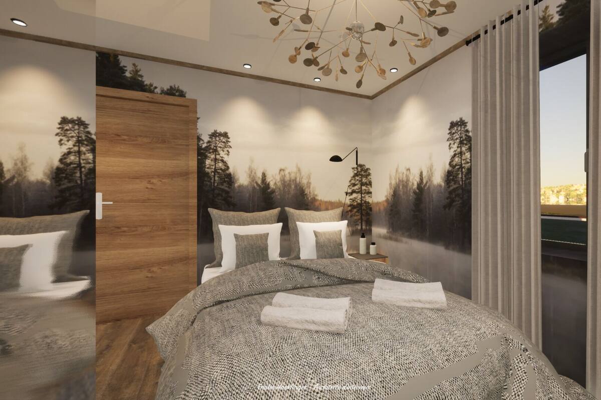 Une chambre à coucher avec un lit, des oreillers, une table de chevet, une lampe, un mur recouvert de panneaux en bois et une vue sur les arbres par la fenêtre.