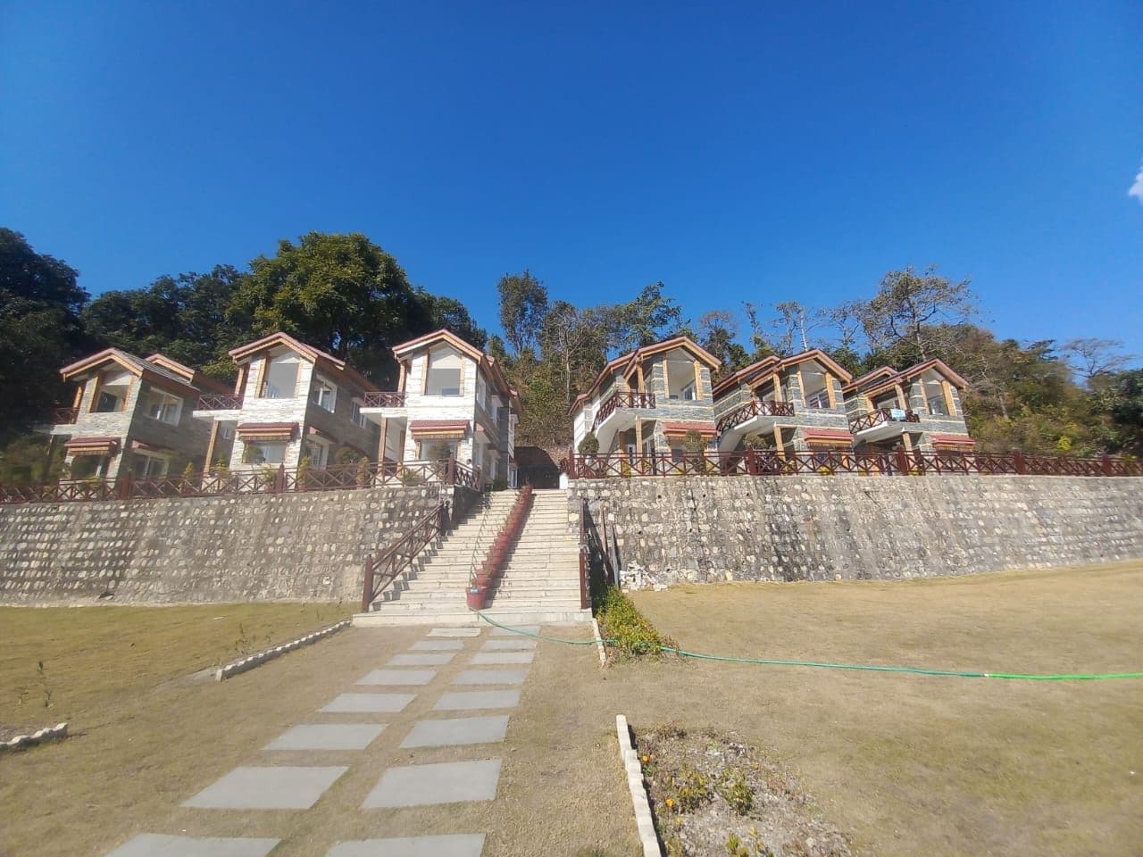 A residential area with multiple two-story houses, a central staircase, and a stone retaining wall.