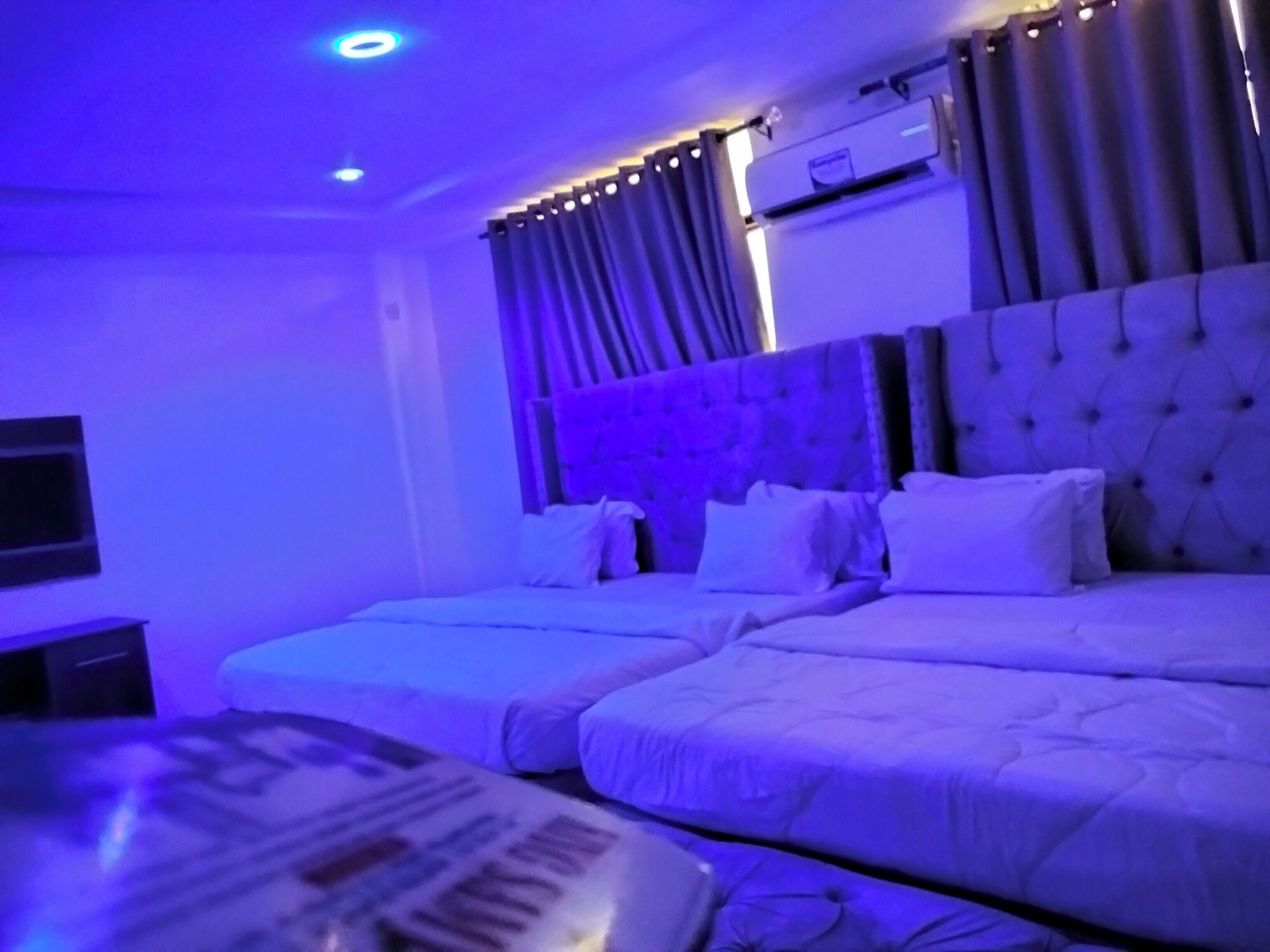 Une chambre d’hôtel avec deux lits, un téléviseur à écran plat et un système de climatisation.